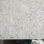 Beyaz ve gri tonlarda doğal taş parçacıkları içeren, cilalı yüzeyli 30x30 cm boyutunda Terrazzo Karo örneği.