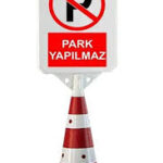 Zemininde siyah taban ve gövdesinde kırmızı-beyaz çizgiler bulunan, üstünde kırmızı bir daire içinde "P" harfi ve altında "Park Yapılmaz" yazısı olan beyaz levhalı plastik duba.