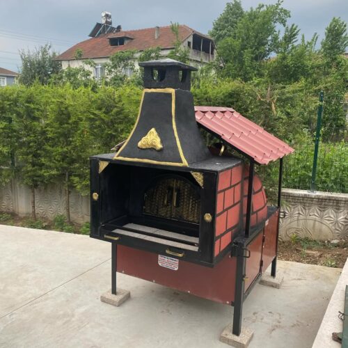 Kırmızı tuğla ve siyah metal kasalı, kiremit çatılı, önünde barbekü/ızgara bölümü olan Selin Köylüm 3 seyyar taş fırın modeli.