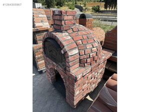 Kırmızı tuğla ile örülmüş, kemerli girişli ve bacalı, 100 cm iç çapa sahip geleneksel sabit taş fırın.