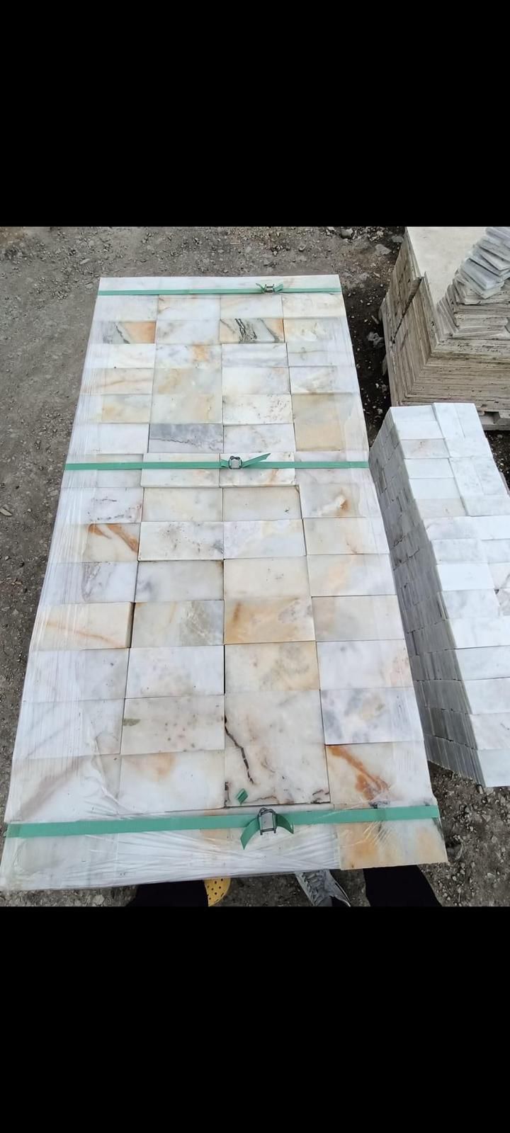 Paket içerisinde sunulan, cilalı yüzeyli ve altın damarlı beyaz mermer tuğla parçaları. Altın sarısı damarlı beyaz mermer 5x15 cm filesiz duvar kaplama taşı.