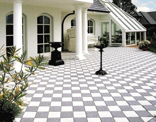 Bahçe teras alanında dama desenli siyah beyaz mineral yüzeyli beton parke taşı uygulaması.